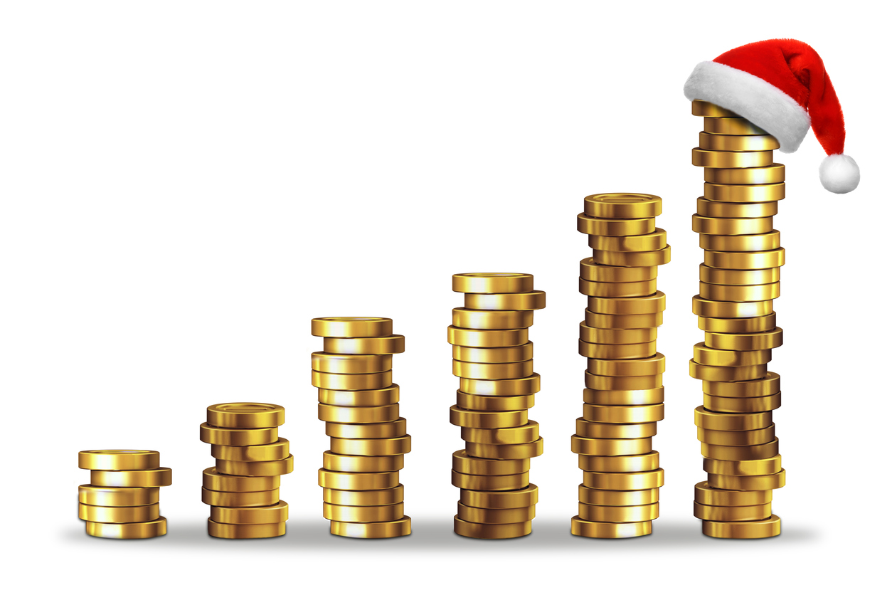 piles of money with a christmas hat on the largest