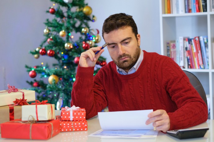 Get your books in order before Christmas! - man assessing papers in christmas jumper