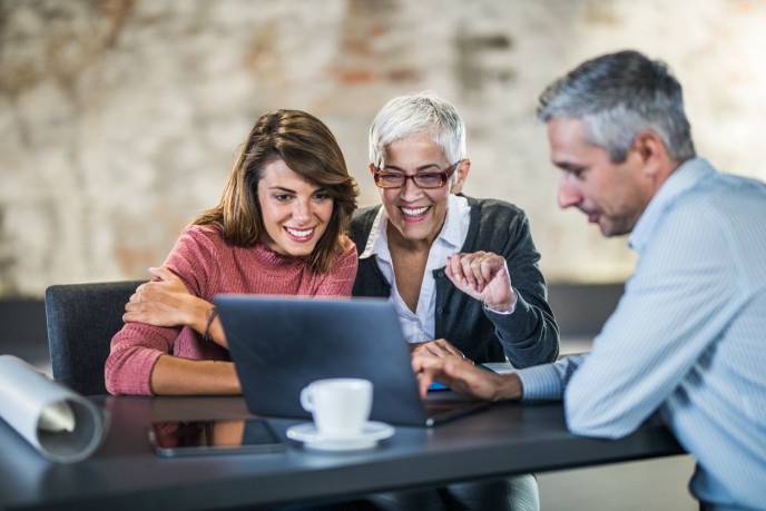 The latest on auto-enrolment compliance - 3 people look at laptop screen