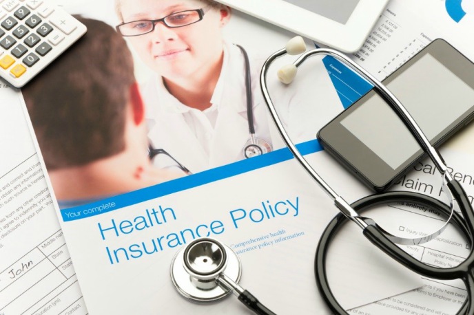 health insurance employee benefits - calculator and leaflet on health insurance with stethoscope