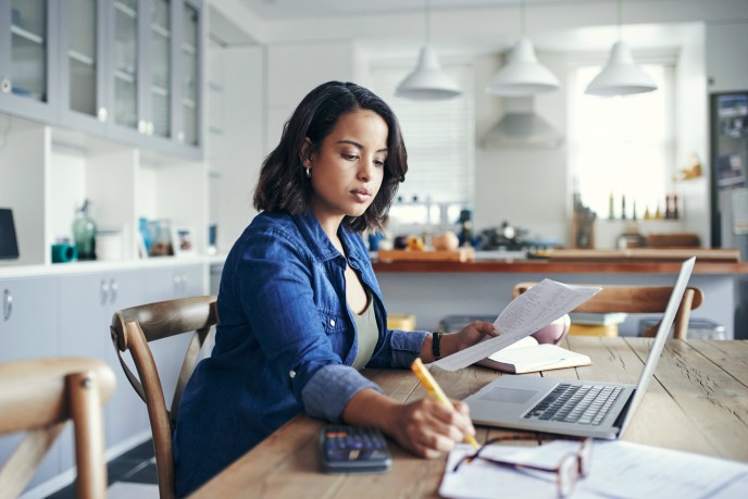 Can I claim back expenses while working from home? - woman with laptop writing on paper