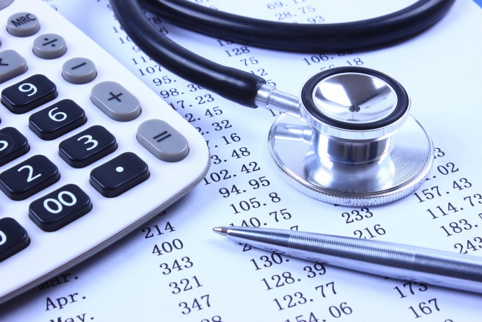 business bookkeeping  - calculator and stethoscope on paper with list of numbers