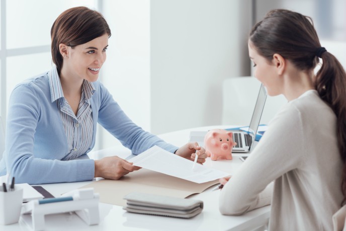 auto-enrolment. woman shows another woman a piece of paper
