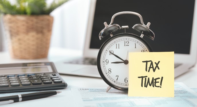 Self-assessment tax returns - alarm clock with sticky note saying tax time