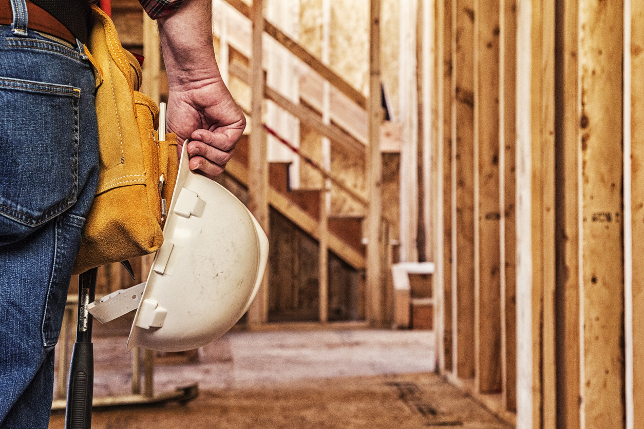 man with hard hat in hand on construction site for CIS