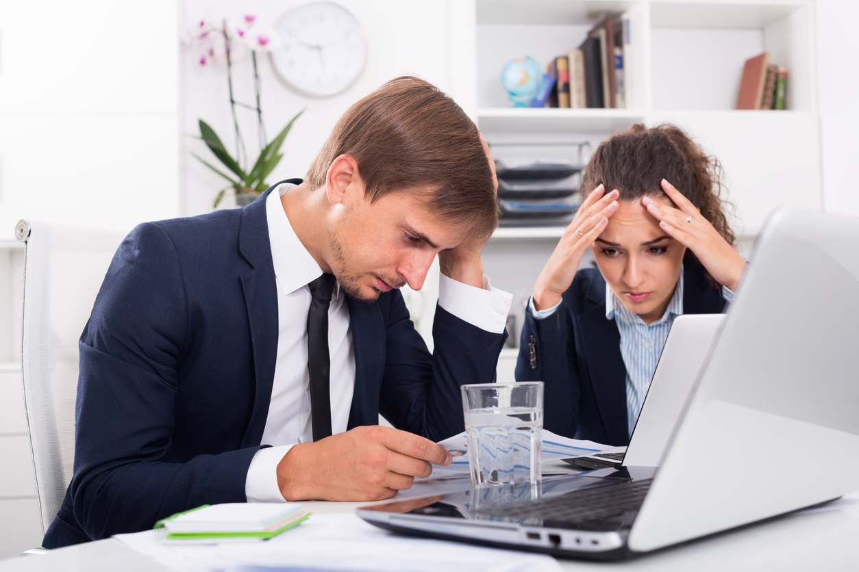 two stressed people at work concentrate on laptop screen
