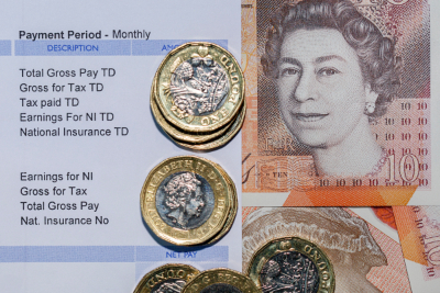 Payslip with £1 coins and £10 note