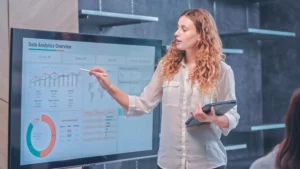 Businesswoman pointing out data analytics on a whiteboard