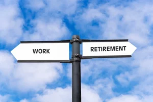 Blue sky and a sign post pointing to ‘work’ and ‘retirement’